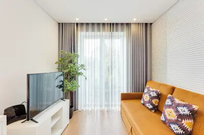 a living room with a couch and a flat screen tv at Almada Downtown Apartment by DA'HOME in Porto