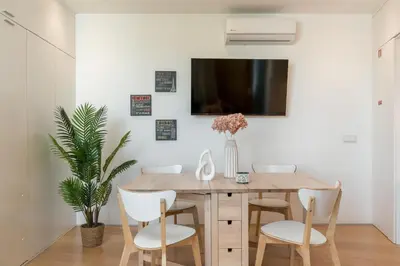 a dining room with a wooden table and white chairs at Alvaro´s Loft Downtown in Porto