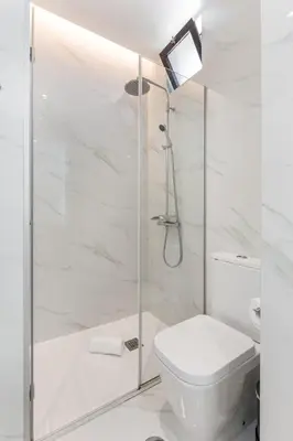 a white bathroom with a toilet and a shower at Alvaro´s Loft Downtown in Porto