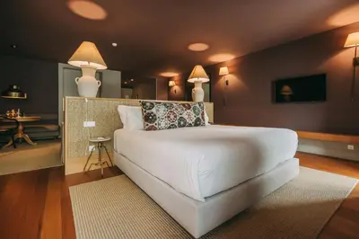 a bedroom with a large white bed and a table at Torel Saboaria in Porto
