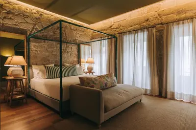 a bedroom with a canopy bed and a couch and windows at Torel Saboaria in Porto