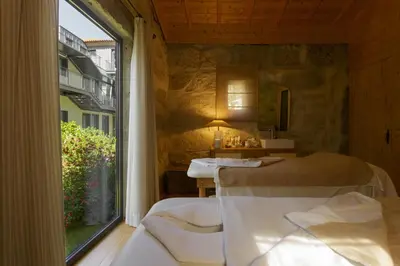 a room with two beds and a large window at Torel Saboaria in Porto