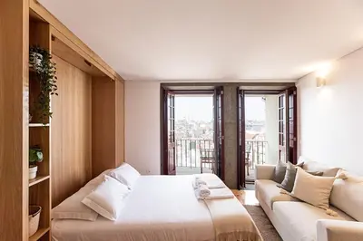 a bedroom with a large bed and a couch at Downtown Studio w/ Gorgeous Views by LovelyStay in Porto