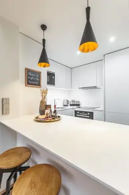 a kitchen with a white counter and stools at OPorto Design Flat in Porto