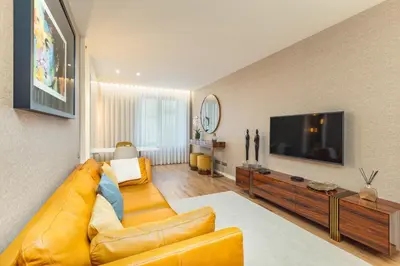 a living room with a yellow couch and a television at OPorto Design Flat in Porto