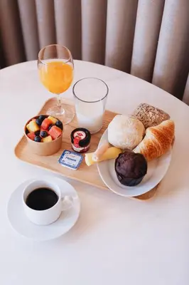 a tray of breakfast foods and a glass of orange juice at ORM Torrinha Apartment in Porto