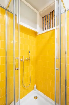 a yellow tiled bathroom with a shower and a tub at VIVA Three Magi Residence in Porto