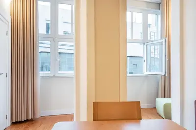a living room with two windows and a table at VIVA Three Magi Residence in Porto