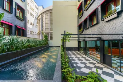 a courtyard with a pool in the middle of a building at The Editory Boulevard Aliados Hotel - Preferred Hotels in Porto