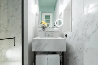 a white bathroom with a sink and a mirror at The Editory Boulevard Aliados Hotel - Preferred Hotels in Porto