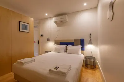 a bedroom with a large bed with white sheets at ORM - Almada Balcony Apartment in Porto
