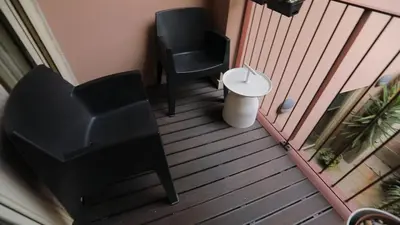 a balcony with a black chair and a stool at ORM - Almada Balcony Apartment in Porto