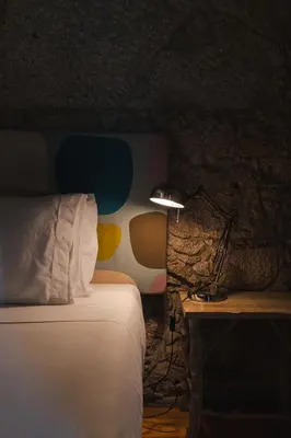 a bedroom with a bed and a lamp on a table at Casa Dos Caldeireiros in Porto