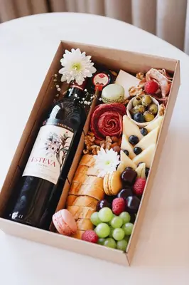 a box of cheese and wine on a table at ORM Carregal Apartment in Porto
