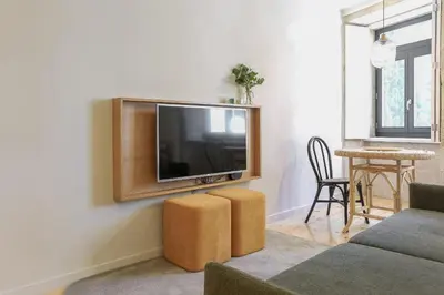 a living room with a flat screen tv on a wall at ORM Carregal Apartment in Porto