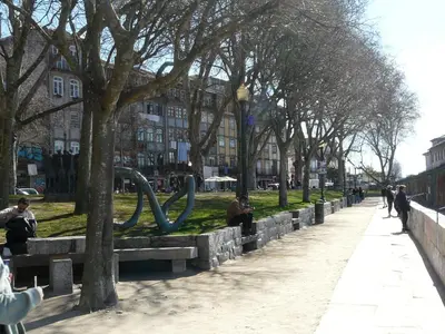 a park with people sitting on benches next to trees at Porto Downtown Taipas in Porto