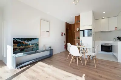 a kitchen and living room with a table and chairs at Host Wise - Bright & Contemporary Flat - Ace Location in Porto