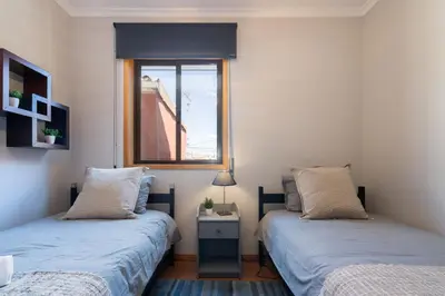 two beds in a room with a window at Host Wise - Lovely & Cozy House - Prime Location in Vila Nova de Gaia