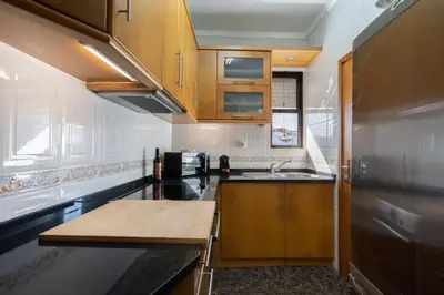 a kitchen with wooden cabinets and a sink at Host Wise - Lovely & Cozy House - Prime Location in Vila Nova de Gaia