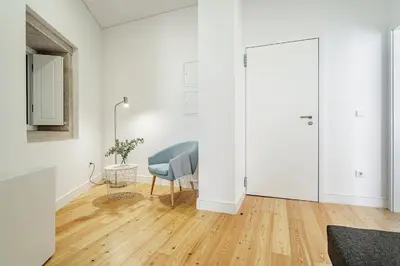 a white living room with a chair and a mirror at Nomad's Formosa - Apartments Porto in Porto