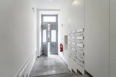 a hallway with white walls and a red fire extinguisher at Nomad's Formosa - Apartments Porto in Porto
