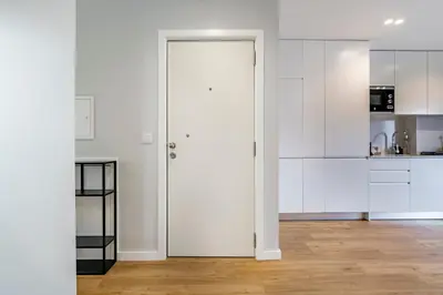 a white kitchen with white cabinets and a wooden floor at Nomad's Sunny Firmeza - 2BED Porto in Porto