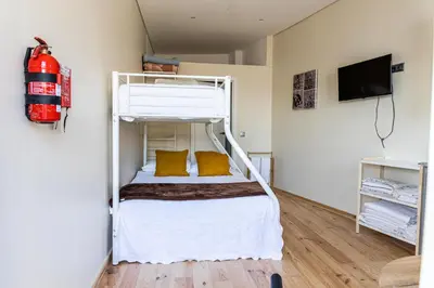 a bedroom with a bunk bed with yellow pillows at House on a rustic Island At Campanha Trainstation in Porto