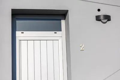 a white garage door with a light above it at House on a rustic Island At Campanha Trainstation in Porto
