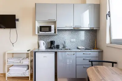 a small kitchen with white cabinets and a table at House on a rustic Island At Campanha Trainstation in Porto