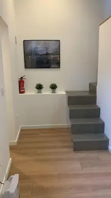 a living room with stairs and potted plants on the wall at Five House 14B in Porto
