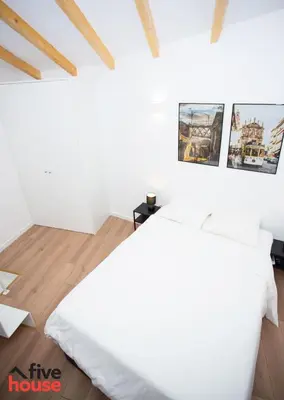 a white bedroom with a large bed and pictures on the wall at Five House 14B in Porto