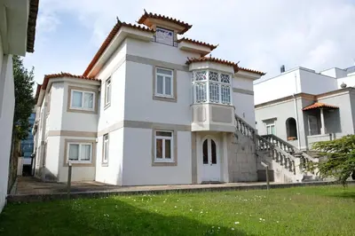 a white house with a clock on top of it at Boavista Studio 99 & Garage in Porto