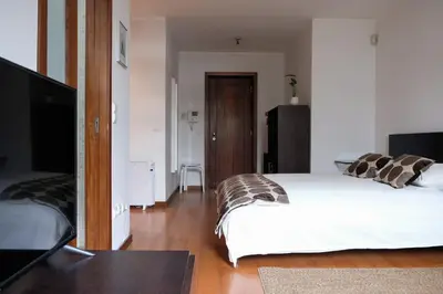 a bedroom with a bed and a desk and a television at Boavista Studio 99 & Garage in Porto