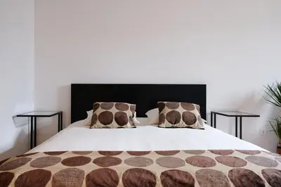 a bed with brown and white sheets and pillows at Boavista Studio 99 & Garage in Porto