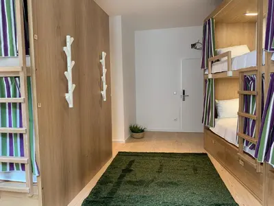a room with two bunk beds and a green rug at Lost Inn Porto Hostel in Porto