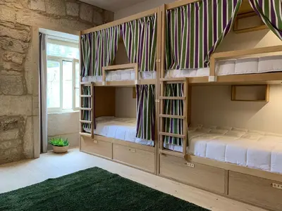 two bunk beds in a room with a window at Lost Inn Porto Hostel in Porto