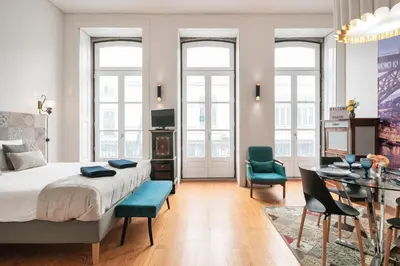 a bedroom with a bed and a table and chairs at Duque Oporto Apartment in Porto
