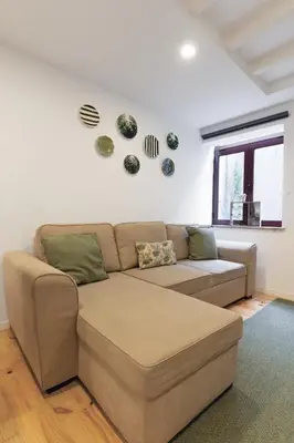 a living room with a couch and plates on the wall at Douro by your side with Pool in Vila Nova de Gaia