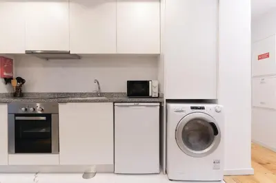 a kitchen with white cabinets and a washing machine at Douro by your side with Pool in Vila Nova de Gaia