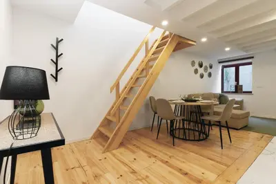 a living room with a staircase and a table and chairs at Douro by your side with Pool in Vila Nova de Gaia