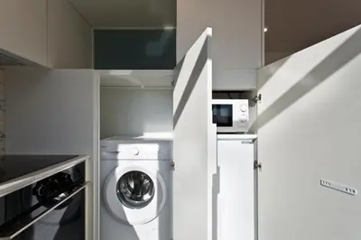 a kitchen with a washing machine and a microwave at B Porto Casa da Música in Porto