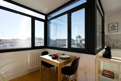 a room with windows and a table and chairs at B Porto Casa da Música in Porto