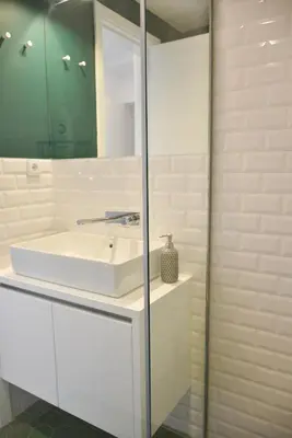 a bathroom with a white sink and a mirror at Lindo apartamento 2 quartos com pátio - Batalha - APT C in Porto