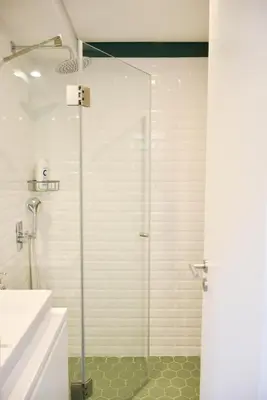 a shower with a glass door in a bathroom at Lindo apartamento 2 quartos com pátio - Batalha - APT C in Porto