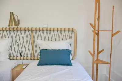 a bed with a blue pillow on top of it at Lindo apartamento 2 quartos com pátio - Batalha - APT C in Porto