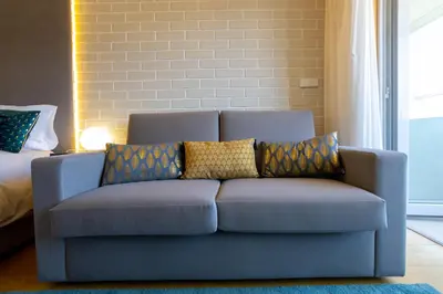 a blue couch with pillows on it in a room at Estúdio Encantador com vistas para o Douro Gaia in Vila Nova de Gaia