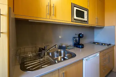 a kitchen with a sink and a microwave at Estúdio Encantador com vistas para o Douro Gaia in Vila Nova de Gaia