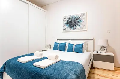 a bedroom with a bed with blue and white at Lóios 1BR Flat Downtown by LovelyStay in Porto