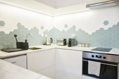 a kitchen with gray hexagonal tiles on the wall at Lindo, funcional e charmoso espaço - Porto - APT H in Porto