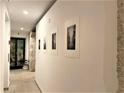 a hallway with several framed photographs on a wall at Lindo, funcional e charmoso espaço - Porto - APT H in Porto